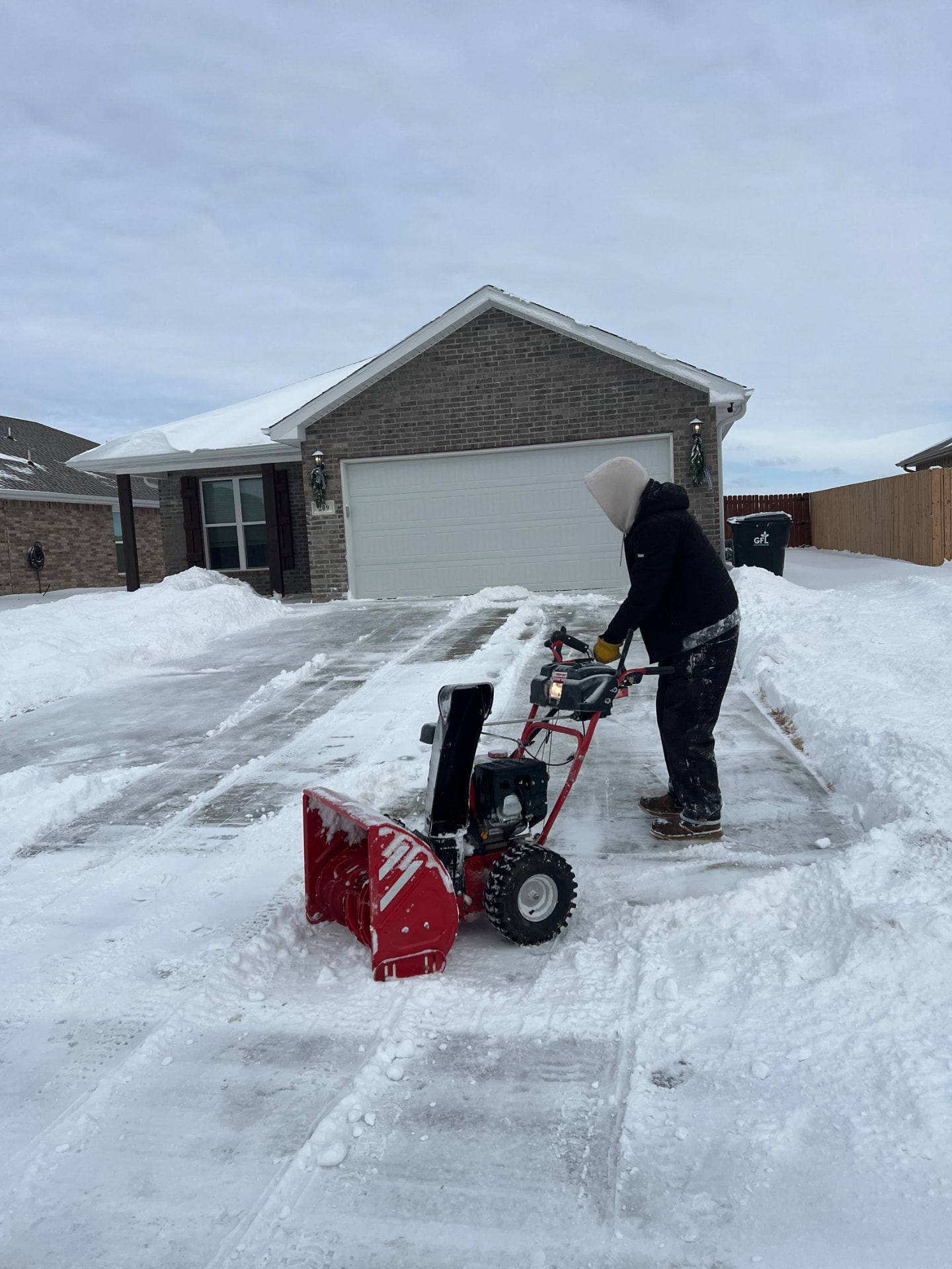 Clearing a snow-covered driveway with a snow blower